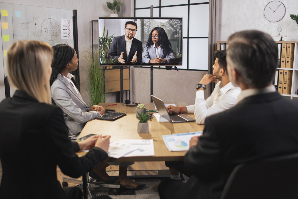 Team of diverse four multiethnic businesspeople having video meeting in boardroom